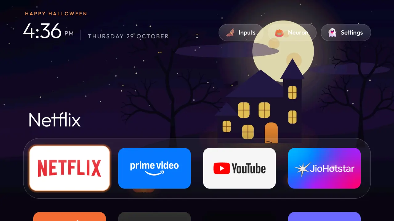 Home on a real TV with the Halloween theme: the illustrated haunted house under a full moon, the dock with Netflix focused, and the jack-o'-lantern, bat and ghost buttons in the top right