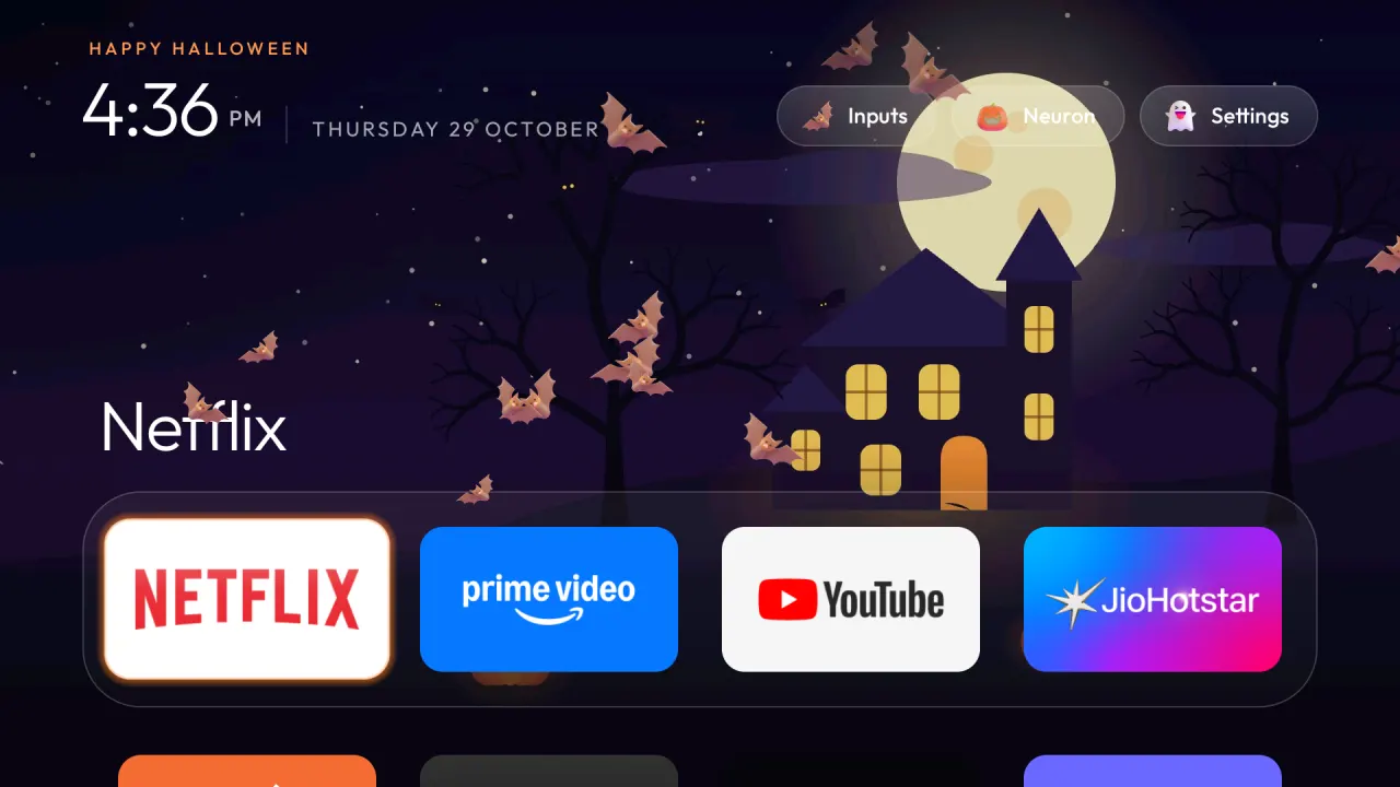 Home with the Halloween theme on a real TV: the illustrated haunted-house wallpaper under a full moon, bats flying across Home, the dock with Netflix focused, and the jack-o'-lantern, bat and ghost buttons in the top right